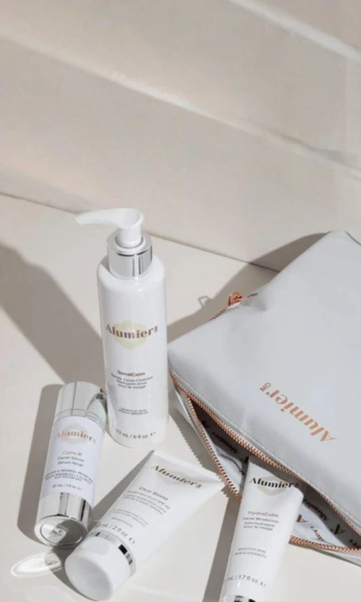 Alumier skincare products with a pouch on a light background