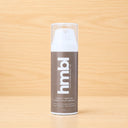 hmbl pigment corrector serum bottle on a wooden surface